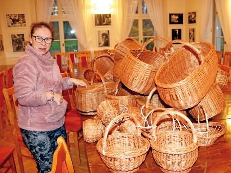 Uczestniczka WTZ prezentuje wykonaną przez nią oraz innych uczestników pracę.