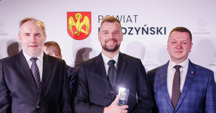 zdjęcie po wręczeniu nagrody, od lewej: wicestarosta Andrzej Zwolak, Mikołaj Brzuzy oraz starosta Tomasz Frejnagiel