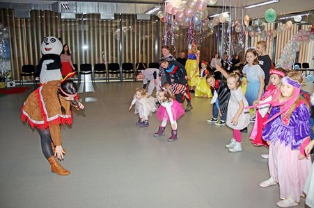 Animatorzy prowadzą zabawę, a dzieci uczestniczą w tańcach i wspólnych grach karnawałowych.