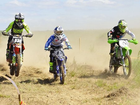 Zdjęcie ilustracyjne zawodników biorących udział w zawodach motocrossowych.
