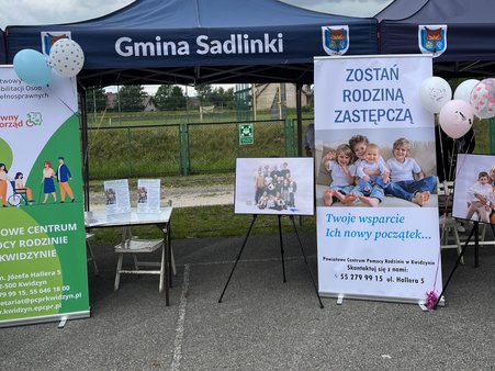 Namiot PCPR z banerami i wystawą informacyjną podczas Gminnego Dnia Dziecka w Sadlinkach.