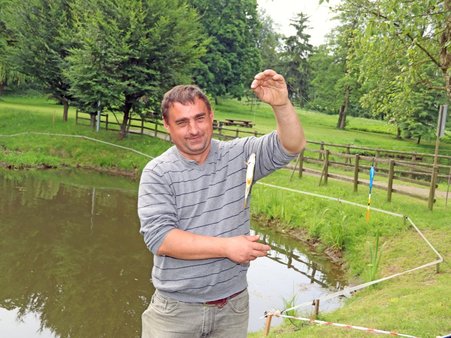 Uczestnik WTZ biorący udział w zawodach prezentuje złowioną rybę.