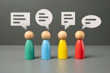 Zdjęcie przedstawia 4 kolorowe pionki na szarym tle, nad nimi białe 4 chmurki z kreskami.