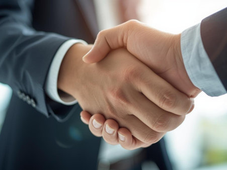 Dwie męskie dłonie skrzyżowane w uścisku.