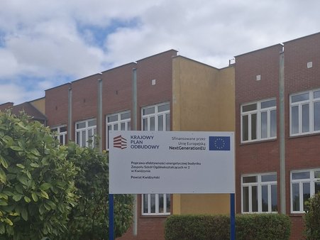 tablica informacyjna o projekcie na tle budynku Zespołu Szkół Ogólnokształcących w Kwidzynie