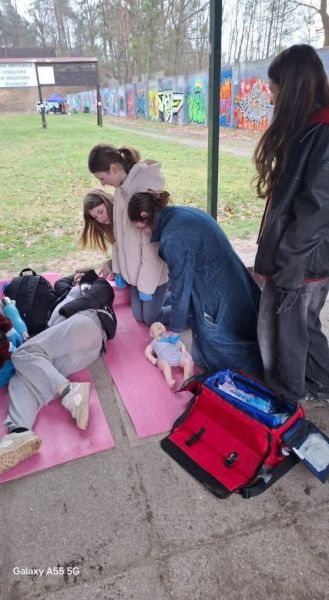 Uczestniczki Mistrzostw Pierwszej Pomocy PCK podczas ćwiczeń z reanimacji i układania poszkodowanego w pozycji bocznej.